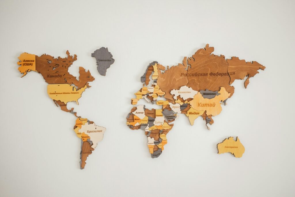 Decorative creative wooden world continents with country names written in Cyrillic attached on white background in light room of studio